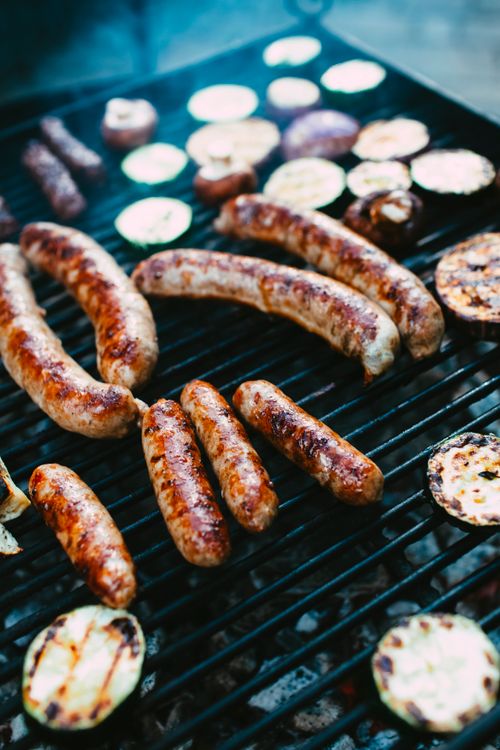 Free Close-up of grilling sausages and vegetables on a barbecue grill outdoors. Stock Photo