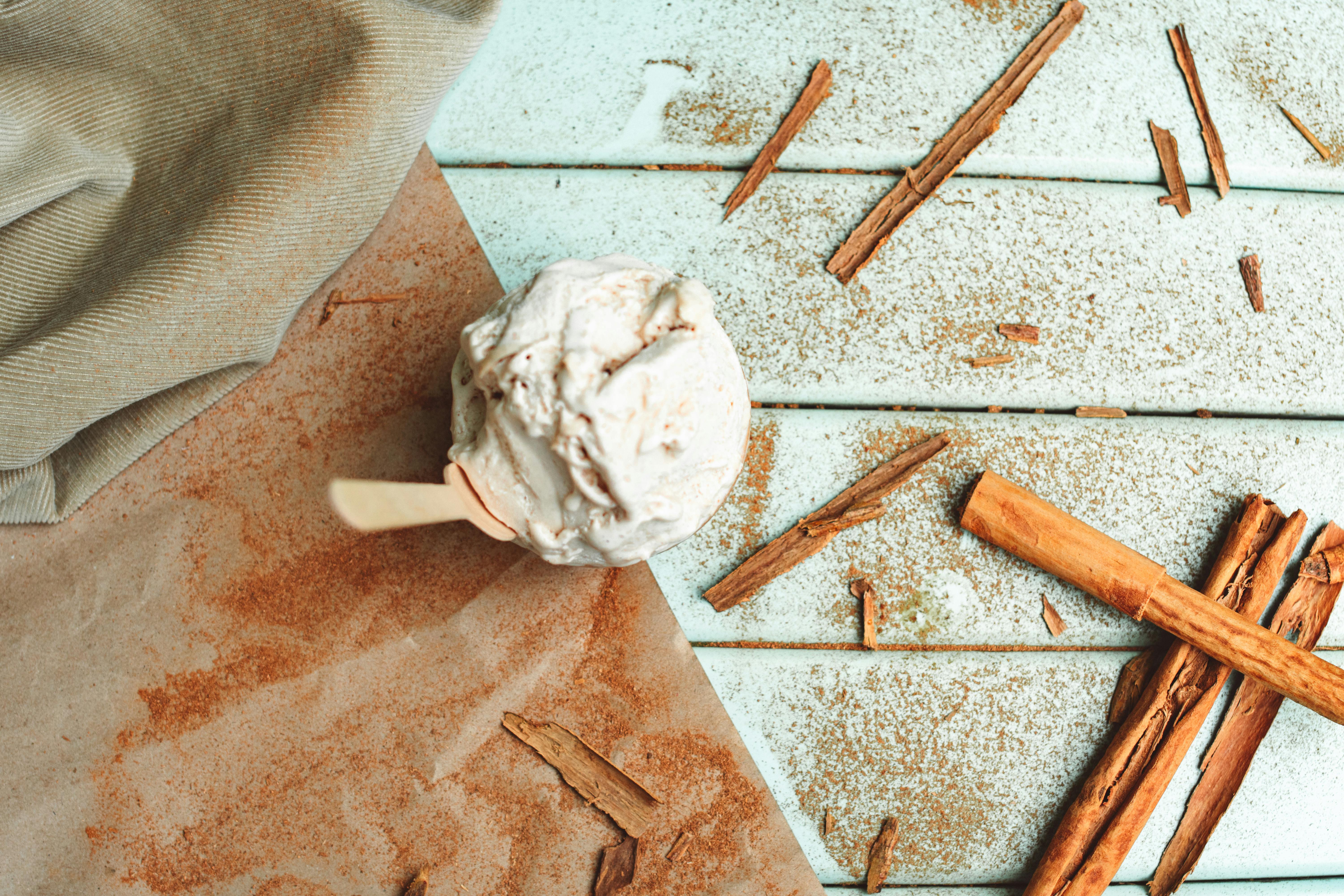 ice cream in a cup and cinnamon sticks