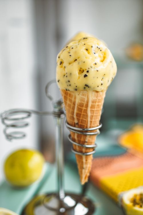 Free Tempting close-up of passionfruit ice cream in a waffle cone on a summer day. Stock Photo