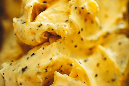 特写镜头中，浓郁的奶油黄色冰淇淋带有明显的香草豆斑点