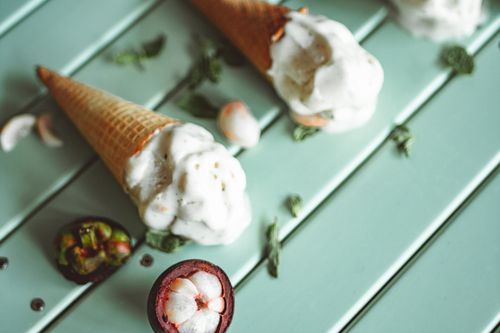 Free Close-up of ice cream cones with exotic mangosteen fruit on a wooden table. Stock Photo