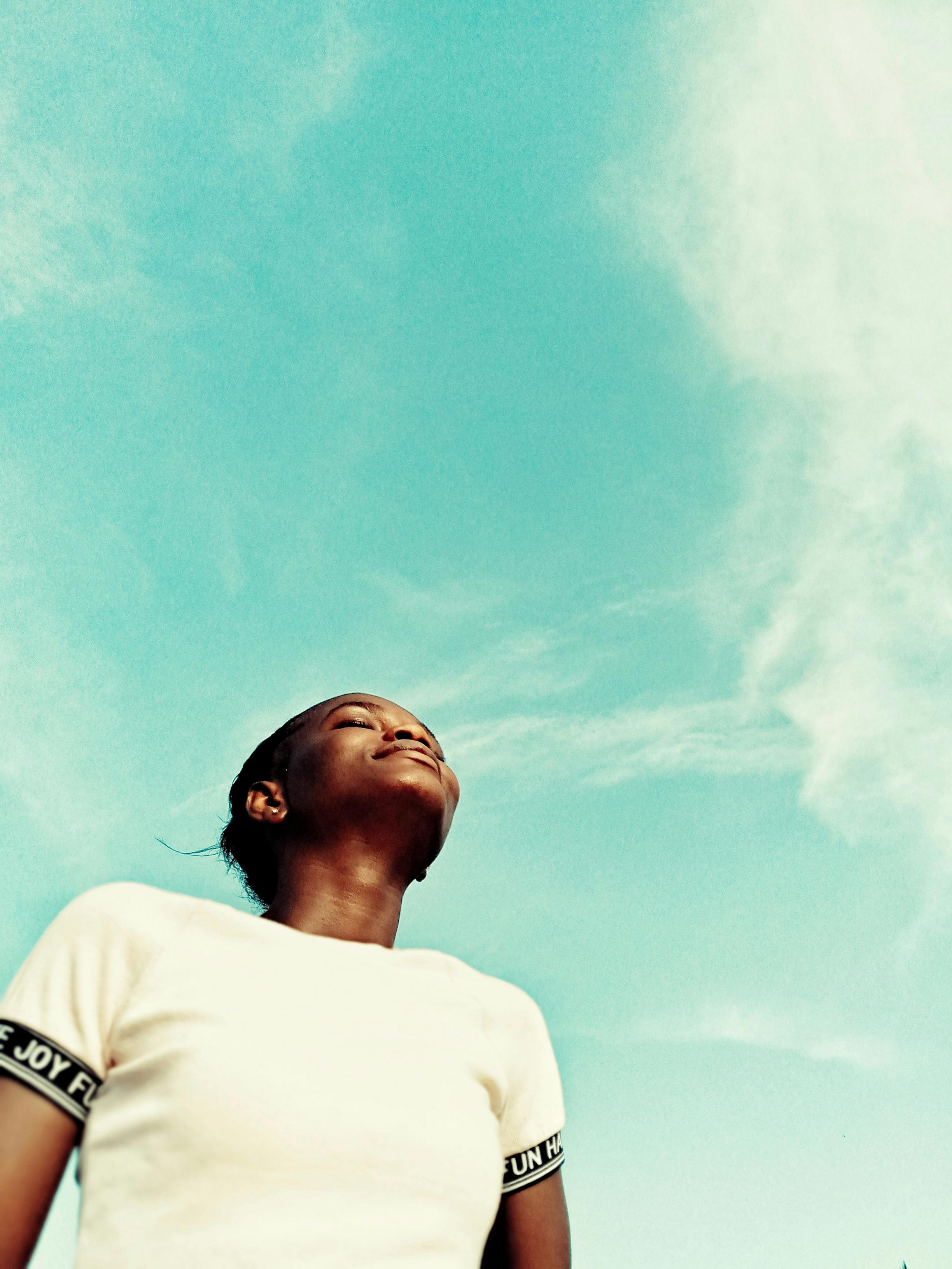 Black woman against cloudy sky · Free Stock Photo