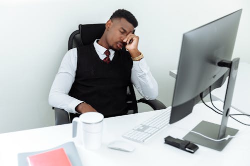 Pria Dengan Rompi Hitam Duduk Di Kursi Bergulir Kantor Hitam