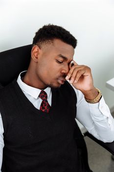 办公室里，一名穿着办公服的男子闭着眼睛，显得很紧张