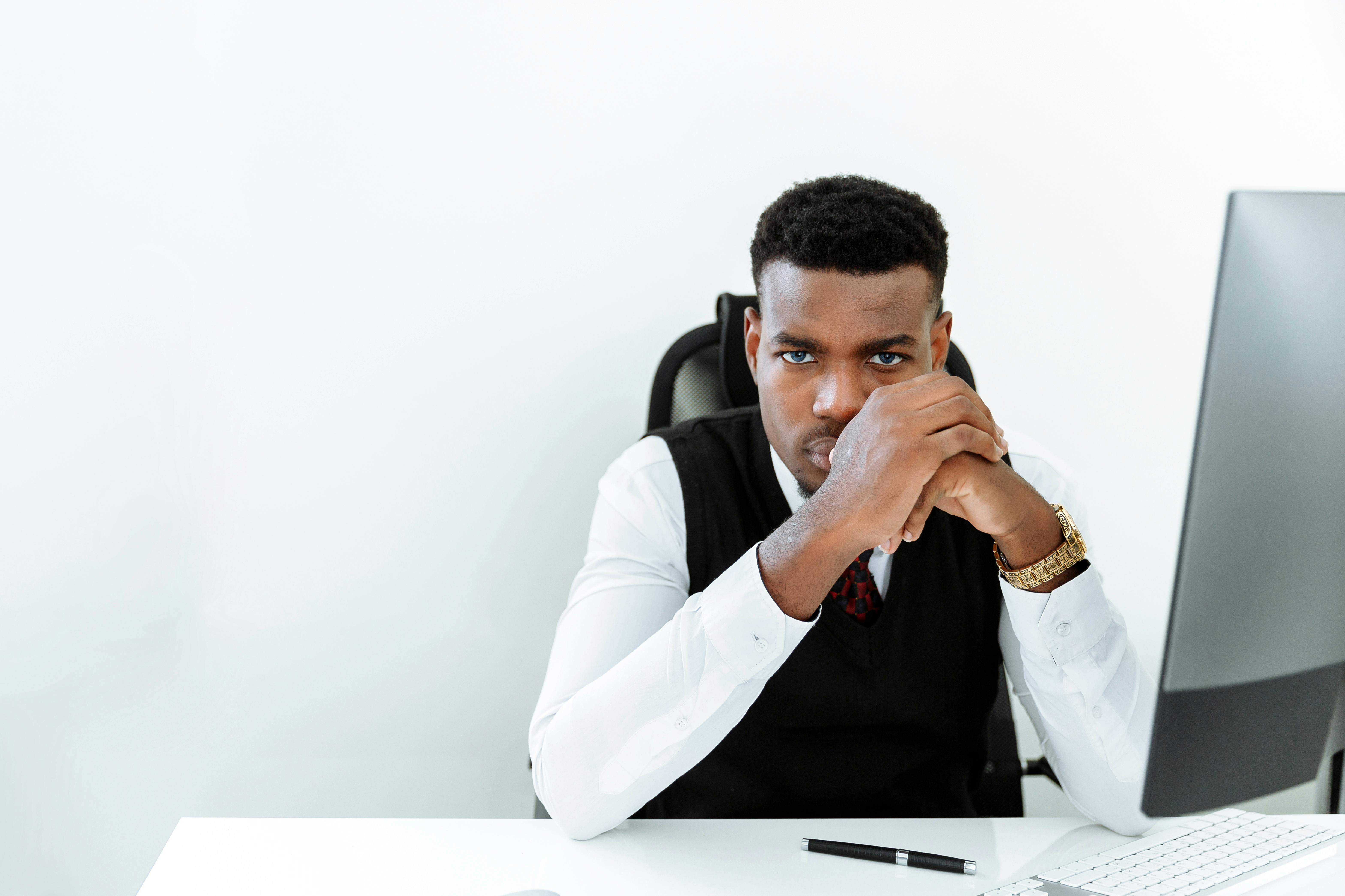 man in white dress shirt sitting on black chair