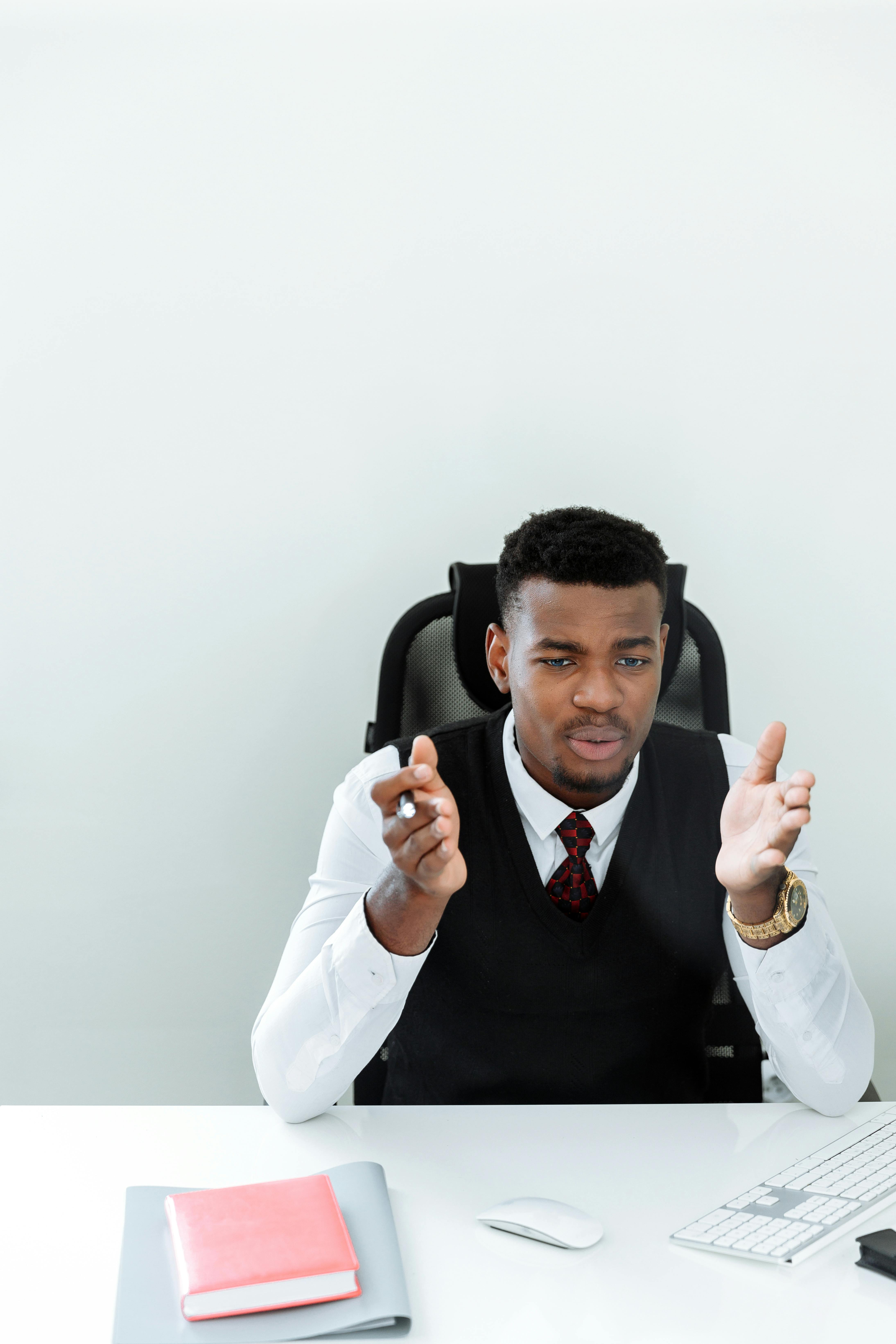 man in white dress shirt holding black smartphone