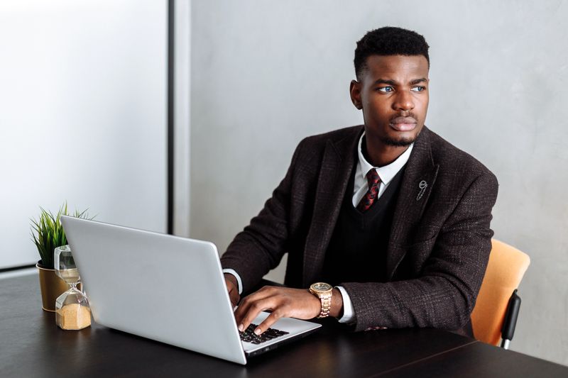 African banker using a laptop in a modern office