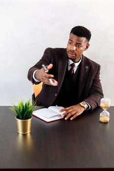在办公室会议上，自信的商人用笔记本和计时器做着手势