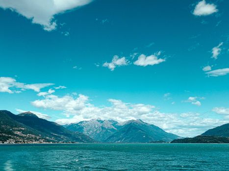 Breathtaking scenery of rocky mountain ridge surrounding turquoise calm lake beneath clear blue sky