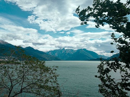 Free Breathtaking view of serene cold mountain lake surrounded by rough stiff mountains and lush trees beneath clear blue sky on sunny weather Stock Photo