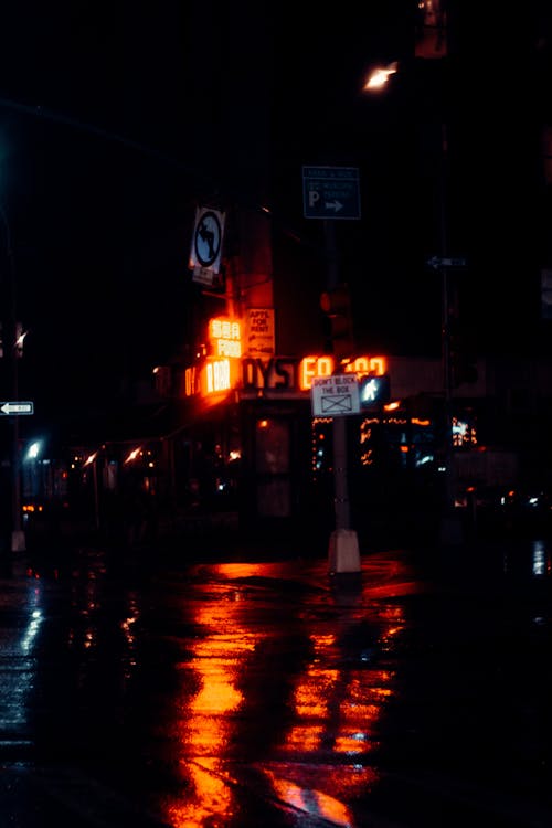 Building with shiny inscriptions illuminating road at night