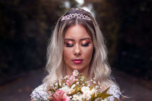 Photo of A Bride Holding a Bouquet of Flowers