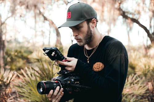 Videographer Looking at the Videos on the Screen of the Camera