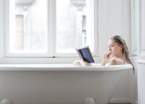 Woman in Bathtub Using Macbook