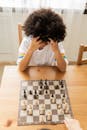 一个聪明的非裔美国女孩在桌上与匿名对手下棋