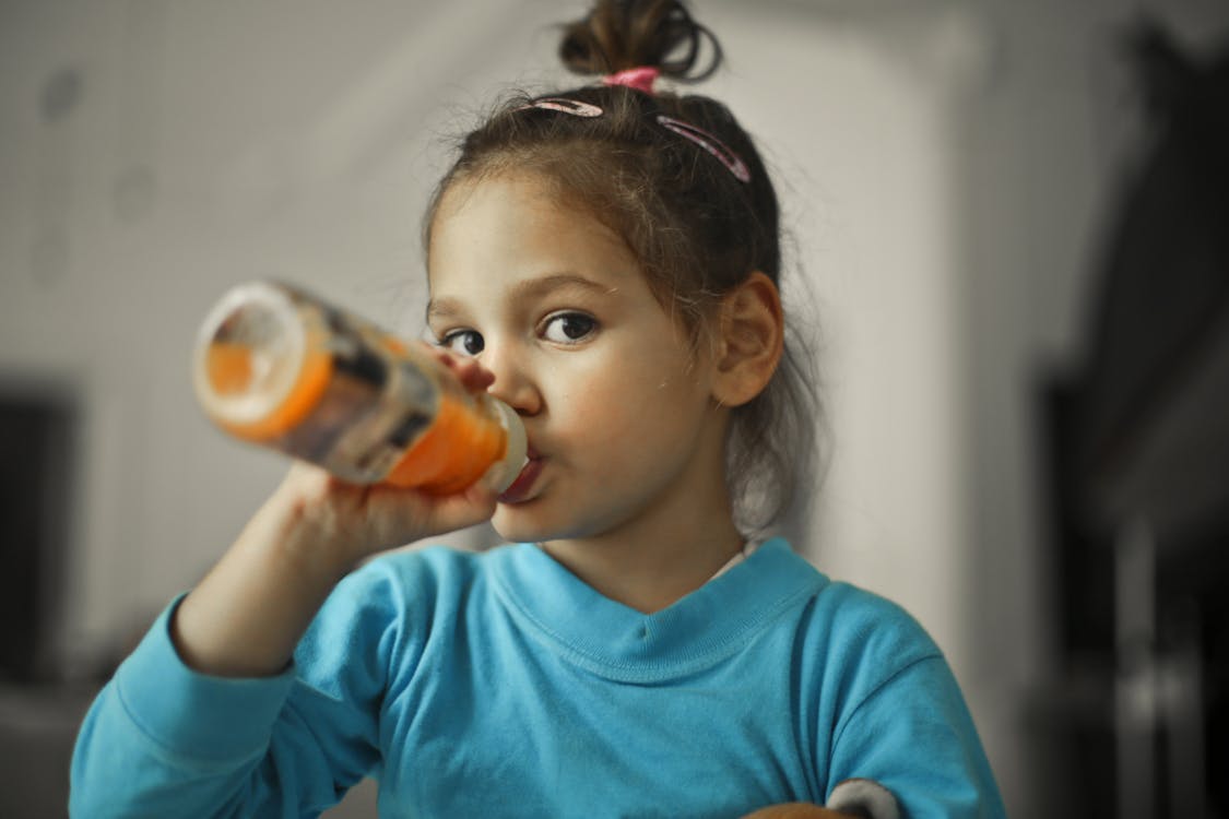 Selective Focus Photo of a Girl Drinking