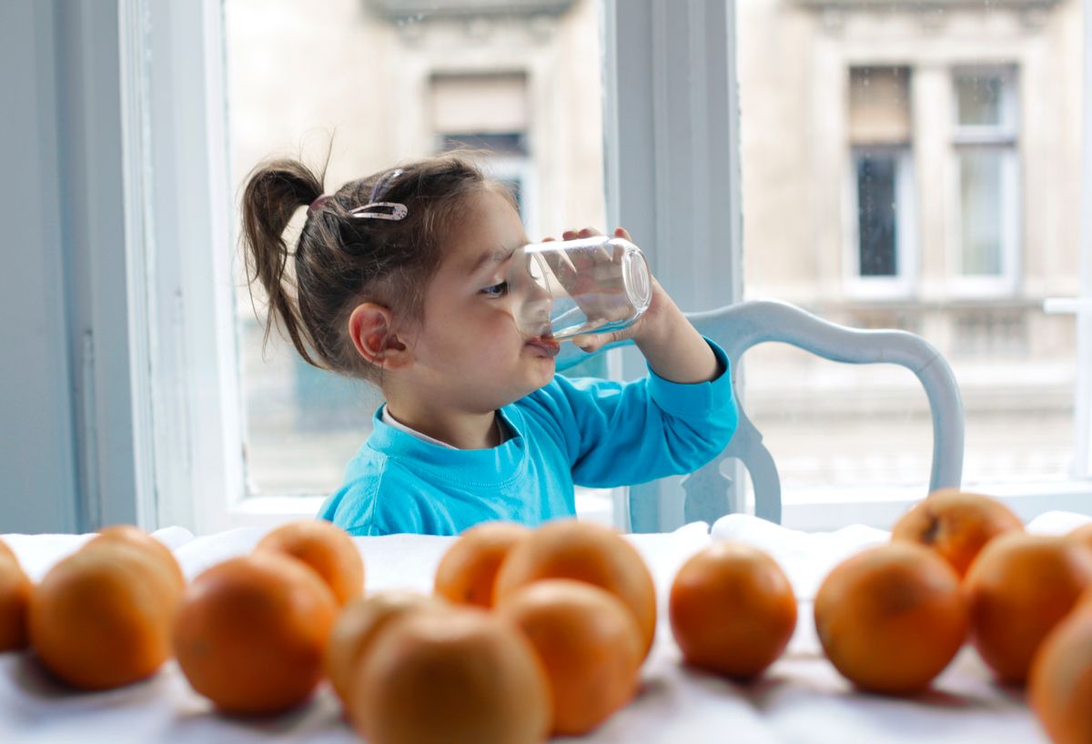 Child happily drinking a glass of clean water