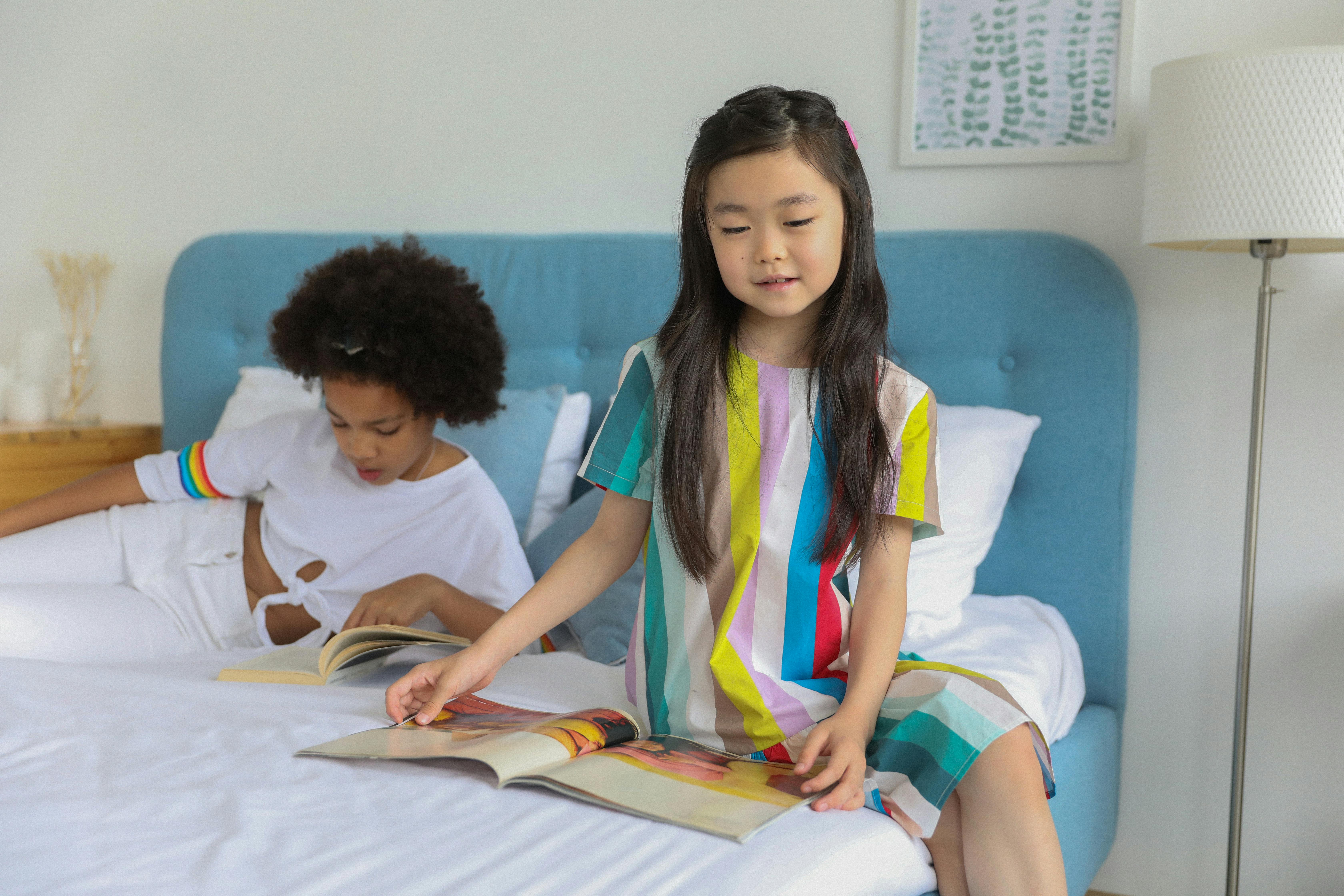 diverse girls reading magazines on bed