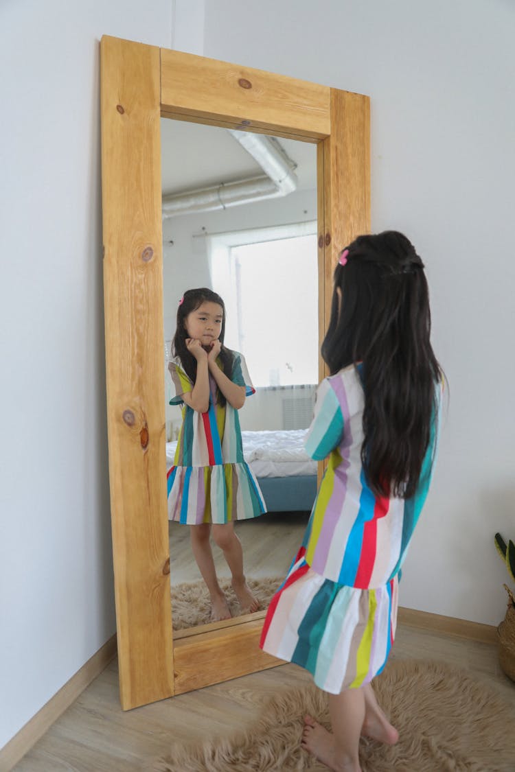 Asian Girl Admiring In Mirror With Wooden Frame