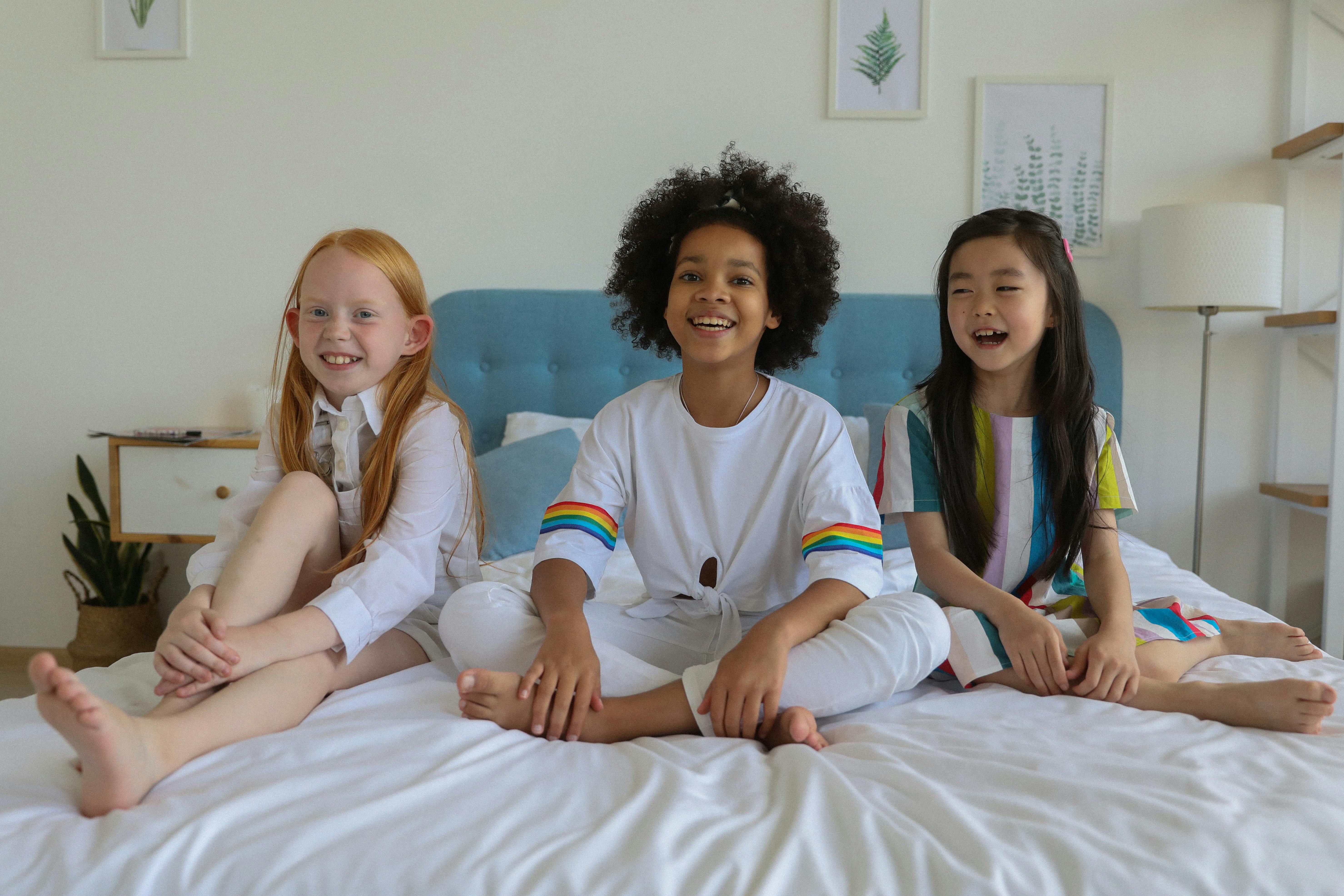 cheerful happy diverse girls spending weekend in comfortable room