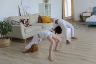 两个年轻女孩在舒适的客厅里练习体操