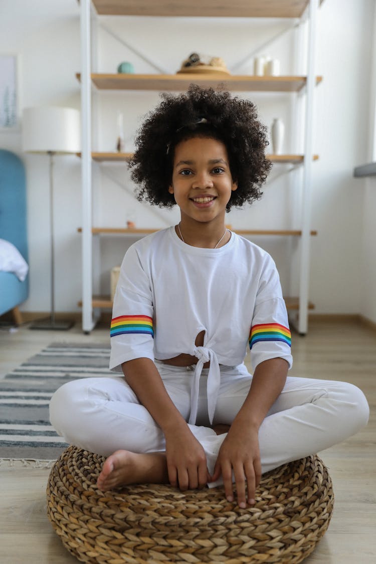 Smiling Ethnic Girl Sitting On Wicker Basket