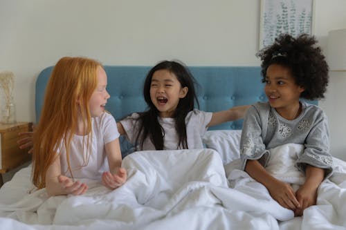Charming little girls on sleepover in bed
