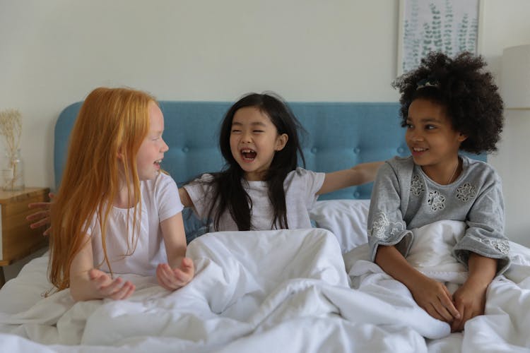 Charming Little Girls On Sleepover In Bed