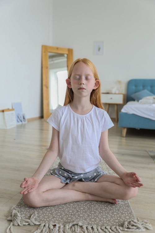 Focused girl meditating while practicing yoga Lotus pose