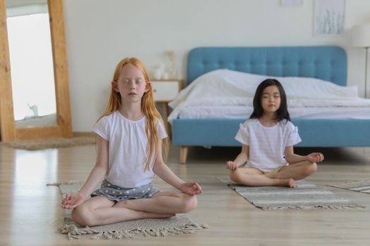 一个穿着多样的女孩在明亮舒适的房间里冥想，她坐在毯子上，旁边有面镜子，白天光线很糟糕