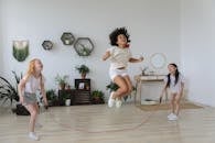 Black girl jumping over rope while playing with friends