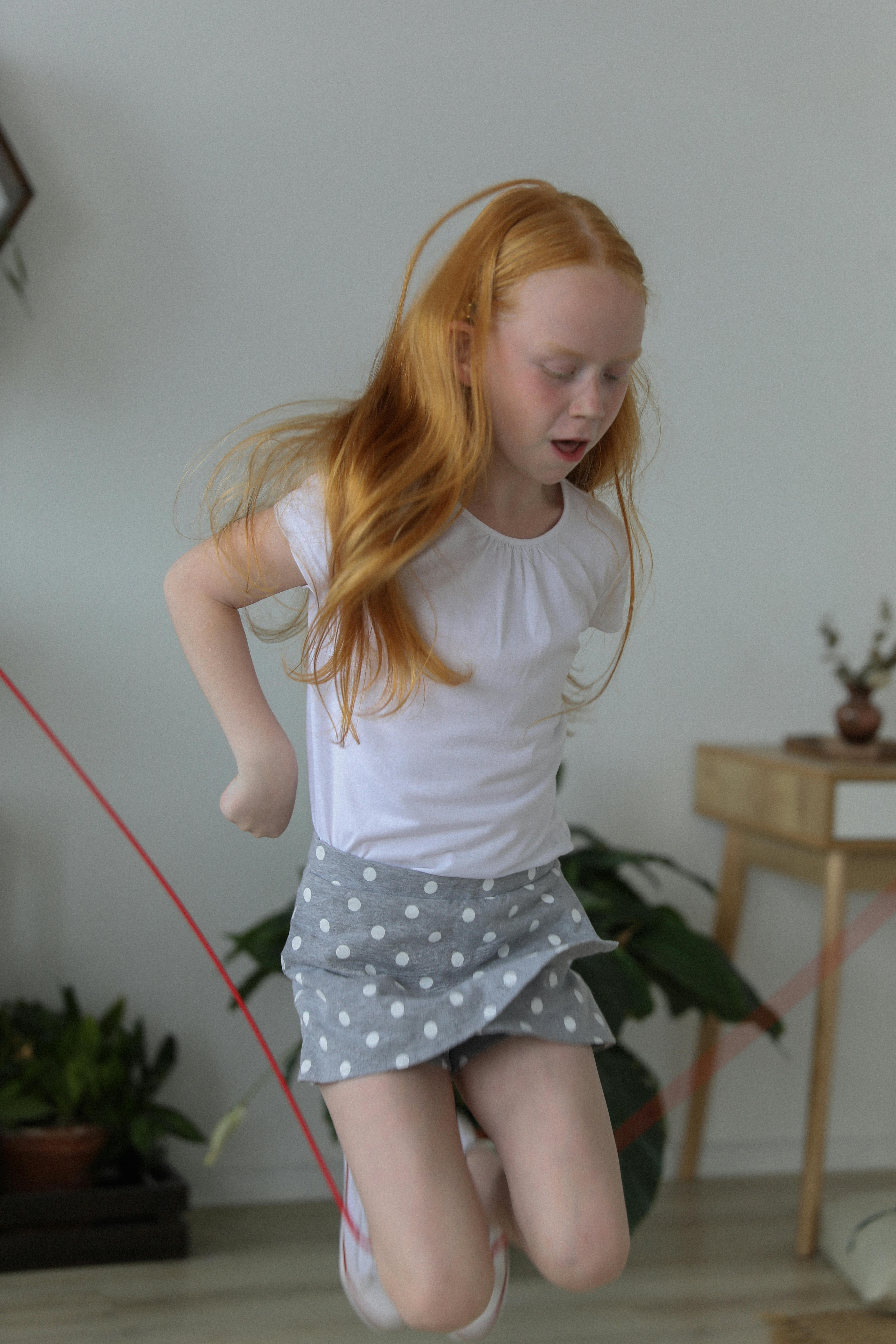 cute little girl jumping rope at home