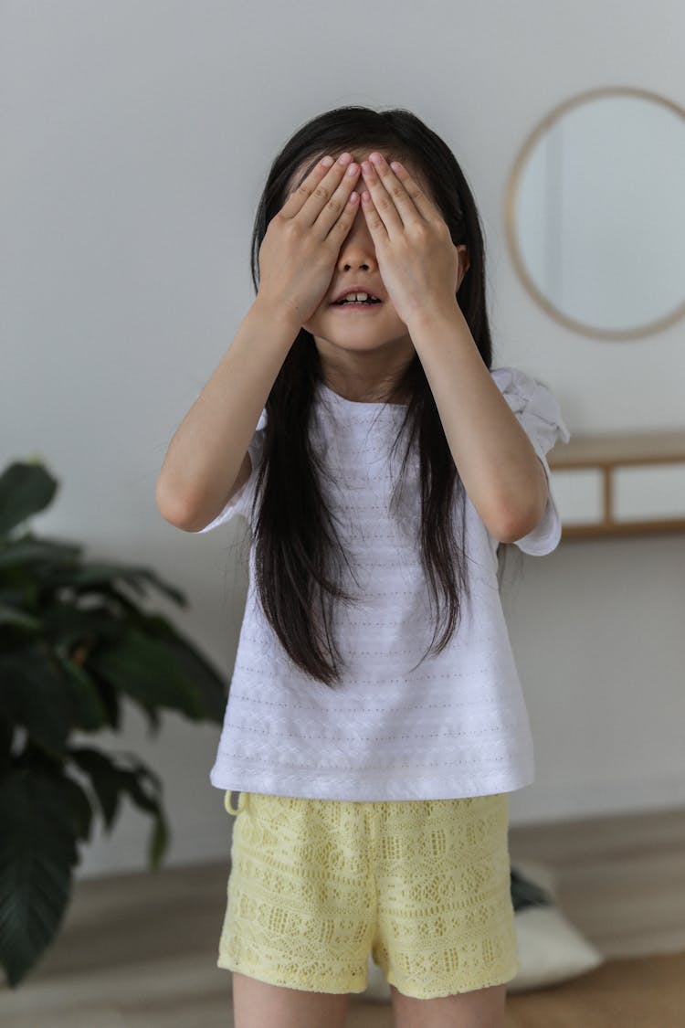 Cute Asian Child Hiding Face With Hands