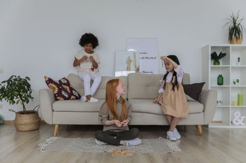 Free Cheerful multiracial children in casual clothes playing games together while resting in cozy living room Stock Photo