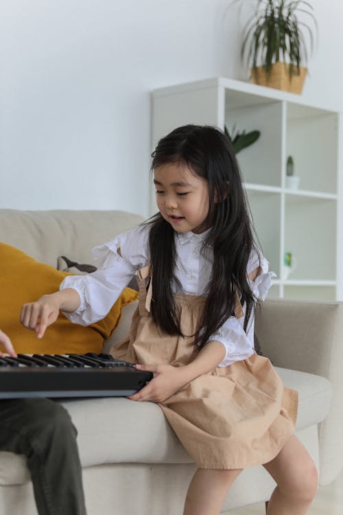 Nettes Asiatisches Kleines Mädchen, Das Synthesizer Spielt