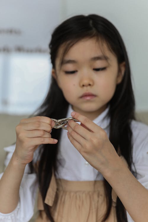 Calm ethnic child in casual clothes resting at home and playing game during weekends