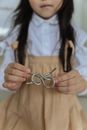 Crop faceless child in casual clothes holding metal wire brain teaser while playing at home