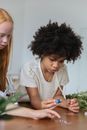 Multiracial little girls with microscope and vials