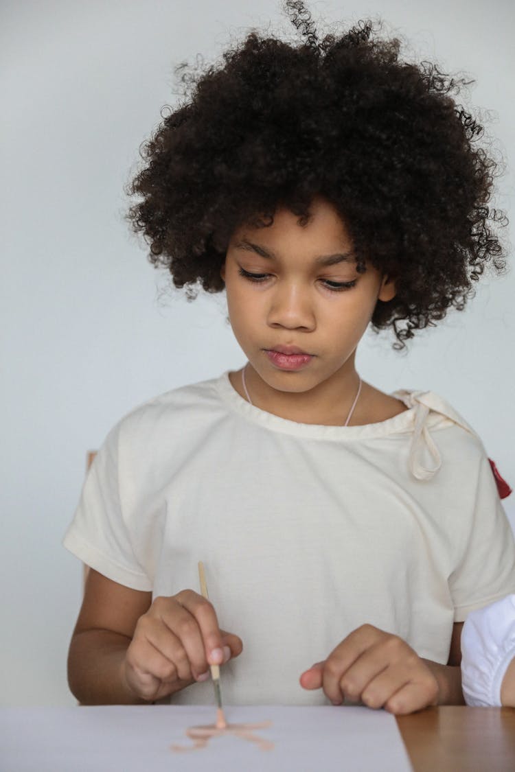 Focused African American Child Drawing With Watercolor On Paper