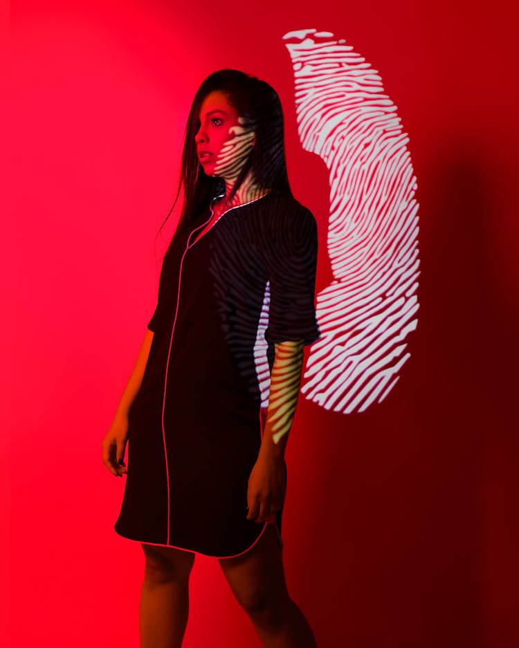 Woman With Fingerprint Reflection On Red Background