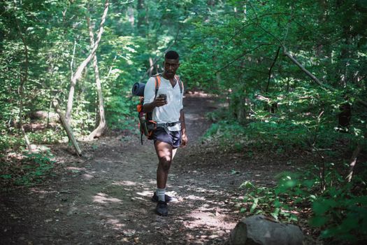 African American man with backpack in forest