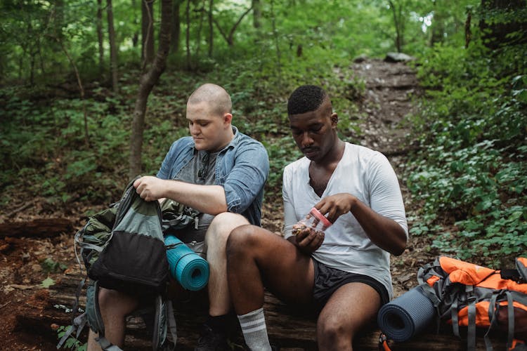 Multiracial Men Eating Snack During Hiking