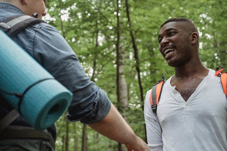 Happy Black Man Looking At Faceless Friend In Forest