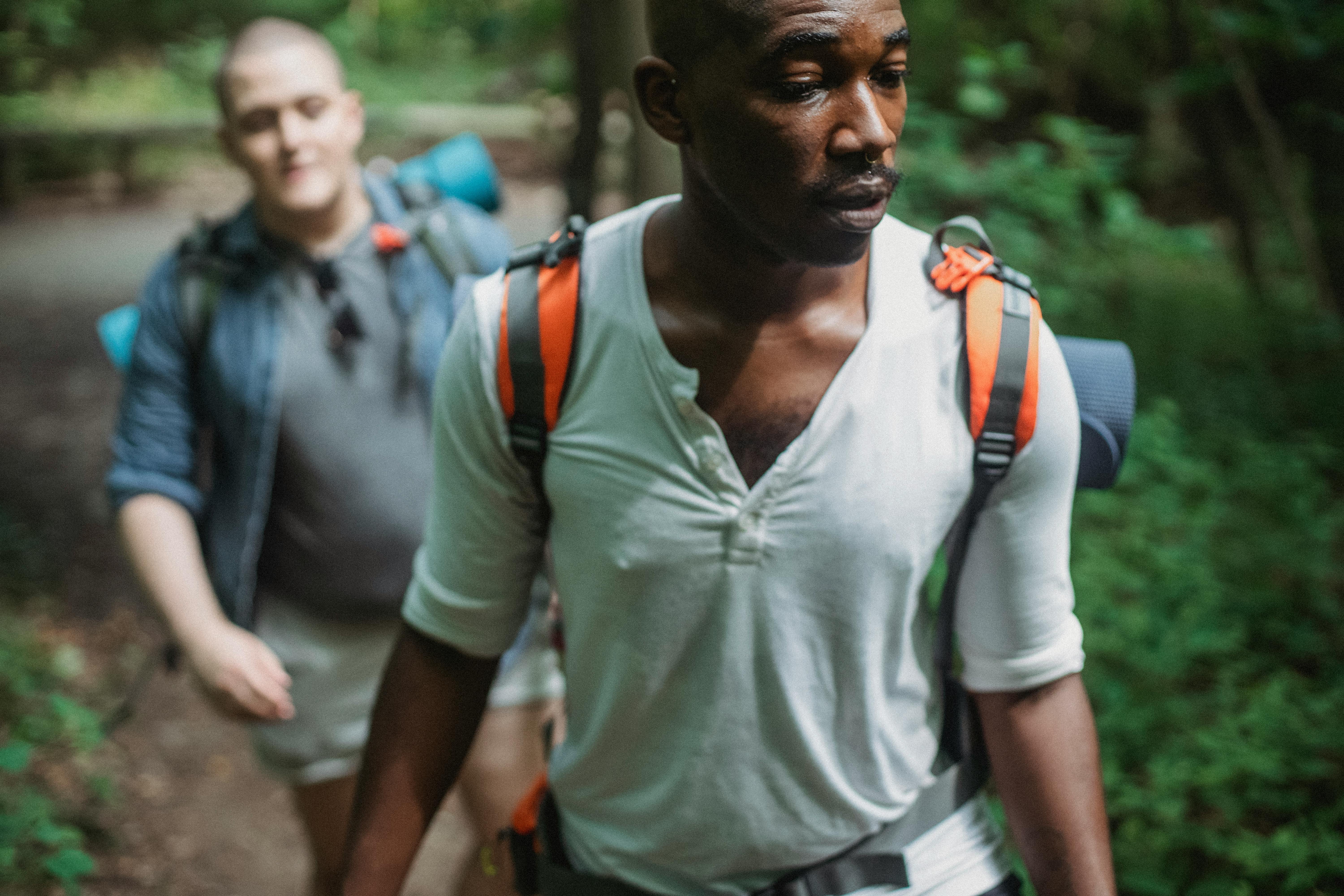 A group of friends hiking up a scenic mountain trail on a sunny day.