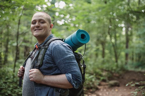 Positive backpacker exploring nature in forest