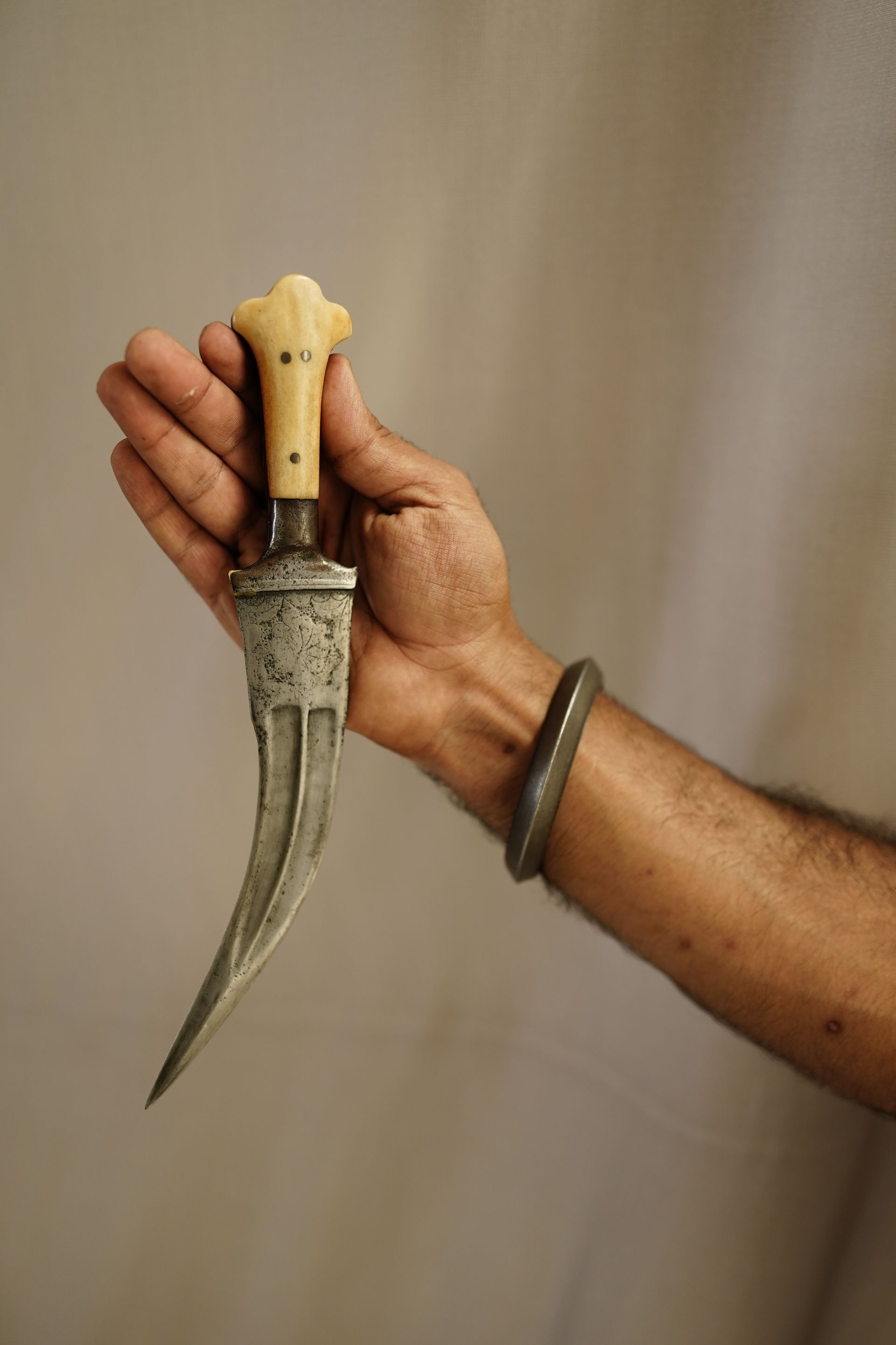 Close-up of a hand gripping a curved combat dagger