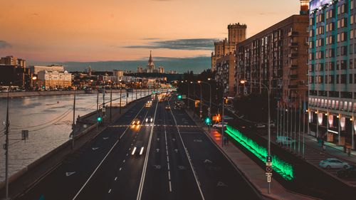 Free Captured cityscape at sunset with illuminated roads and architectural skyline by the river. Stock Photo