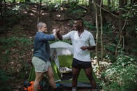 Happy men near tent in forest