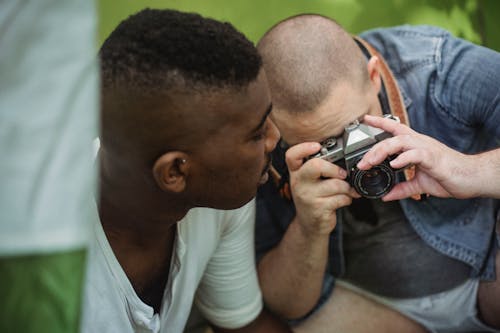 Man taking photo on camera while hiking with black friend