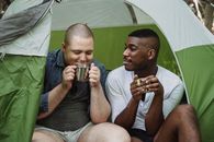 Diverse friends drinking tea in tent